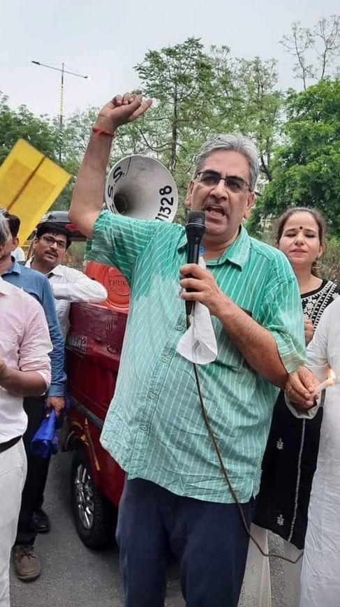 A DUTA speaker raises a fist while addressing a protest through a megaphone